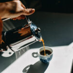 Pouring espresso coffee into an espresso cup with a mocha pot stefania pelfini la waziya photography 1 150x150